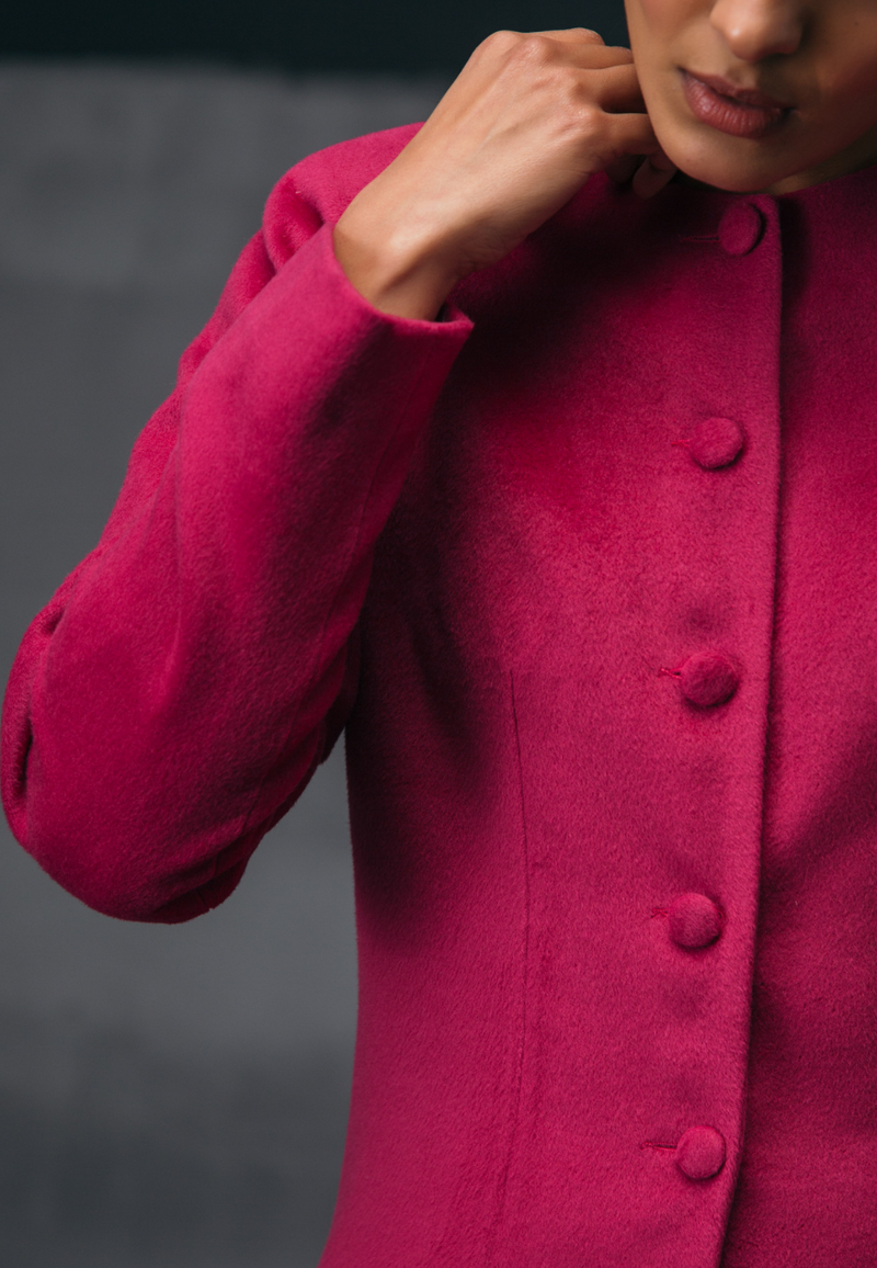 Mannat Gupta's collection of women's jackets and coats. This collarless pink wool coat features wool buttons as closures on the front. It has long sleeves and is cut right on the knee. It the perfect coat for breezy winters. You can wear it to work or for your next dinner plan with girlfriends. Pair it with straight pants and a cropped sweater along with pumps to complete the look.