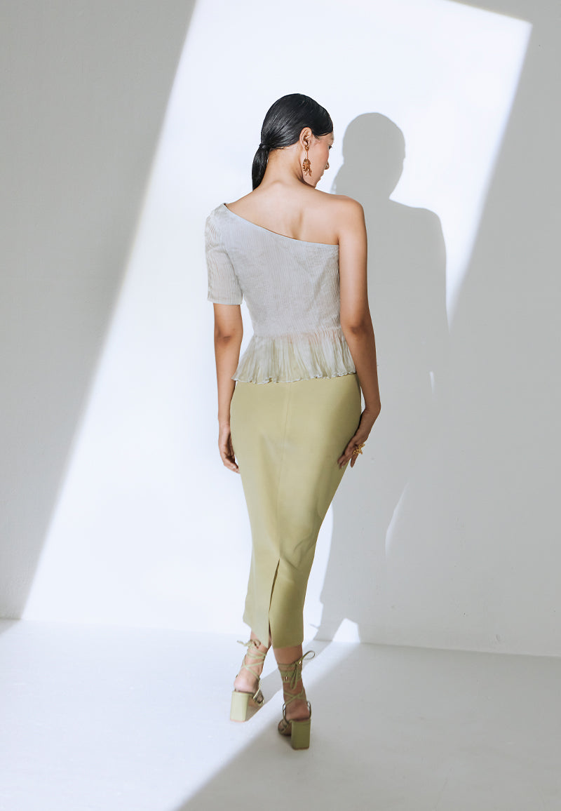 Make a statement with this simple yet classy pastel olive green midi skirt constructed in crepe. This high-waisted skirt has a bodycon fit and is mid-calf in length. It features a zip closure at the center back with a flap opening at the bottom for free movement. A versatile and minimal piece that can be paired with any of our bodysuits, corsets or bustiers. Pair yours with minimal gold jewelry and heeled sandals to complete the look.