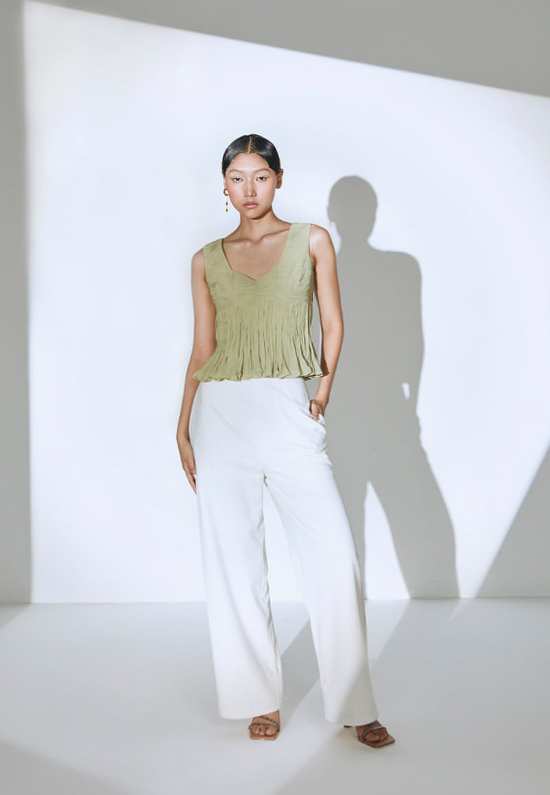 Doll-up in this ruched, sleeveless top in pastel olive green. This lightweight georgette bodycon top is peplum-inspired and features a sweetheart neckline. The top has a zip closure at the center back. Pair it with a skirt, jeans or pants with sneakers or heeled sandals for a day out in the city.