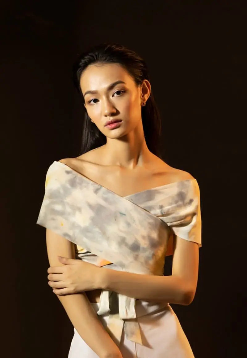 Mannat Gupta's collection of women's crop tops. This off-shoulder crop top is made using silk in a tie dye print of yellow and grey. The wrap-around style makes the half sleeves crop top functional and appealing. Pair the top with pants, jeans or shorts with sneakers or heels for your next brunch or dinner.