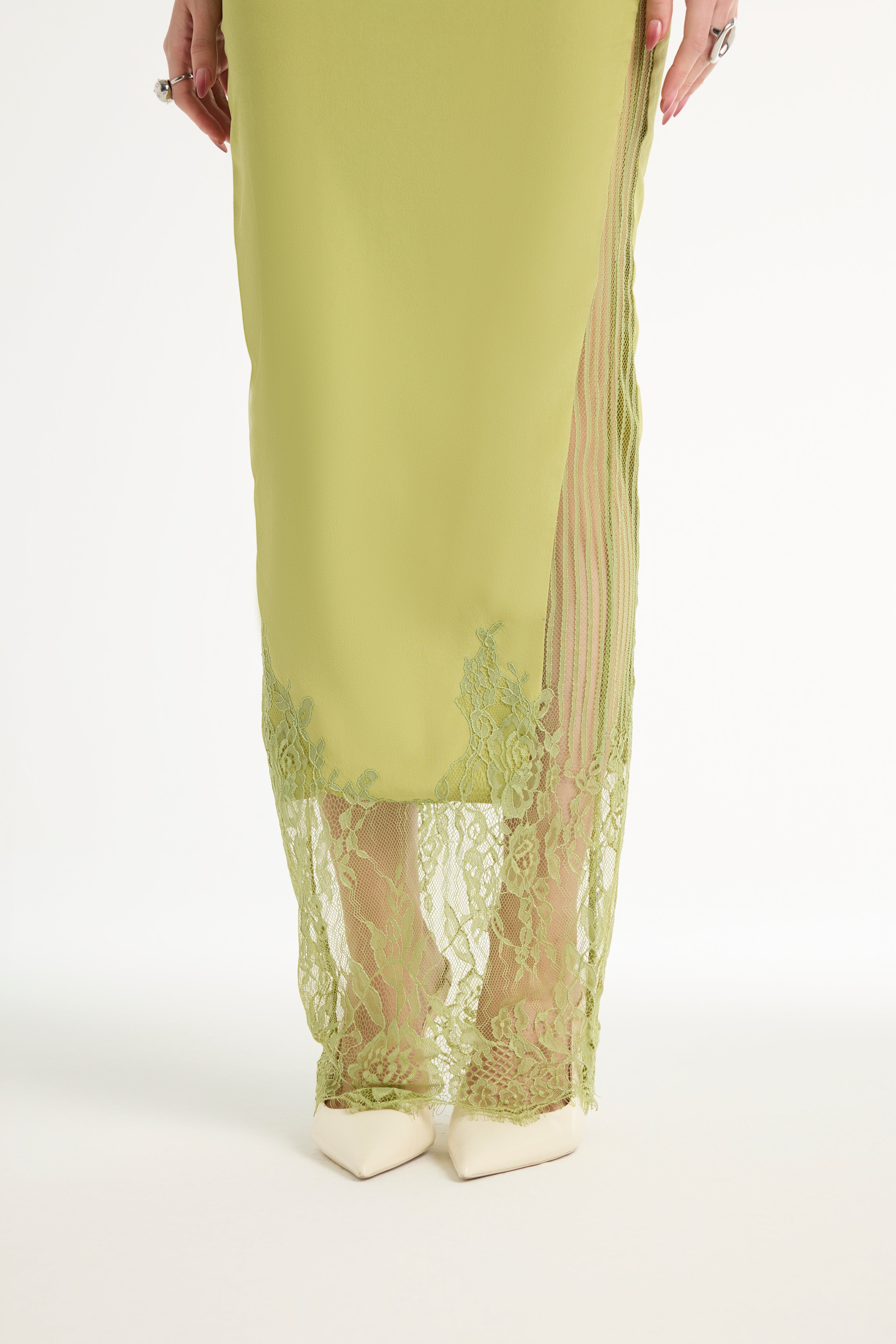 Green dress with lace detailing on a white background