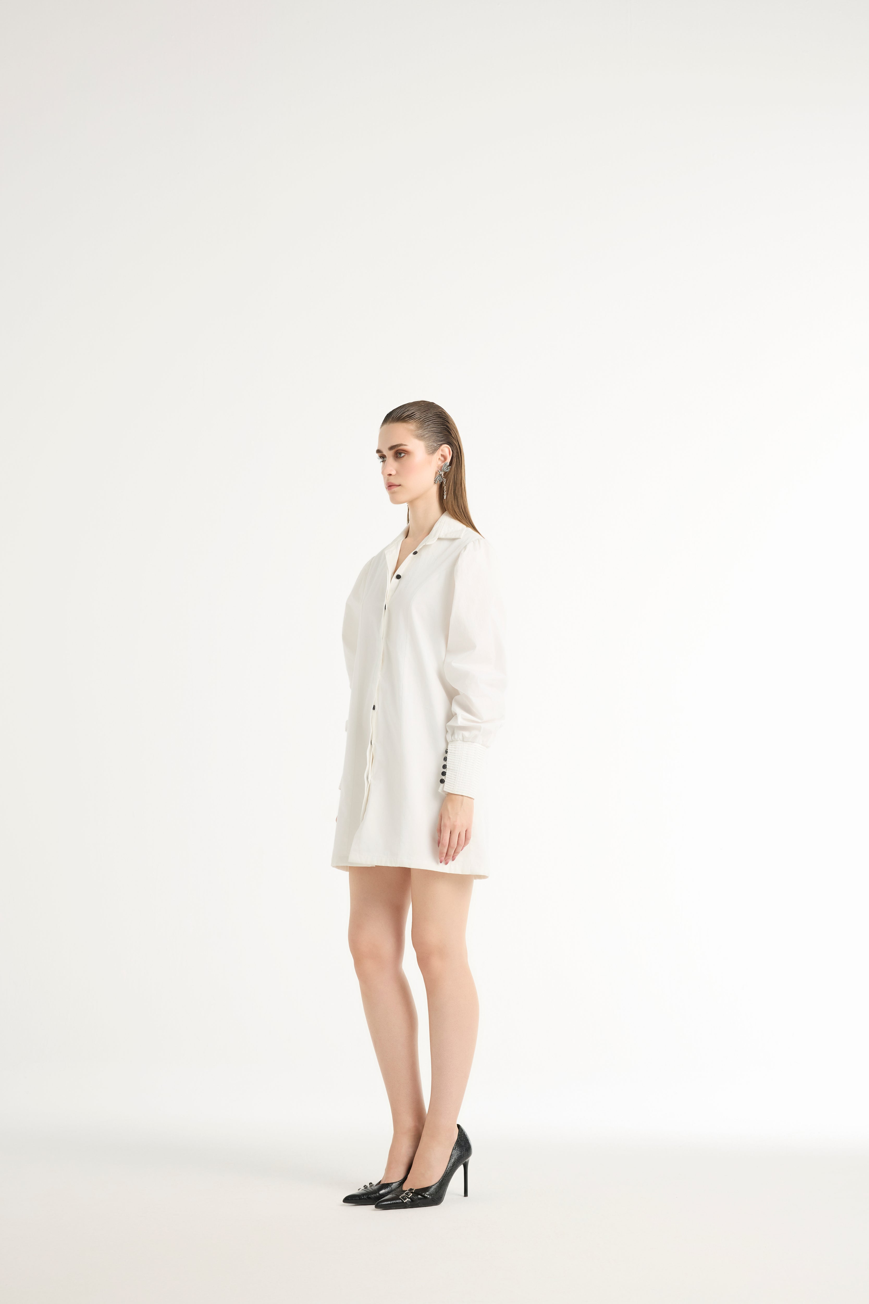 Woman wearing a white shirt dress on a white background
