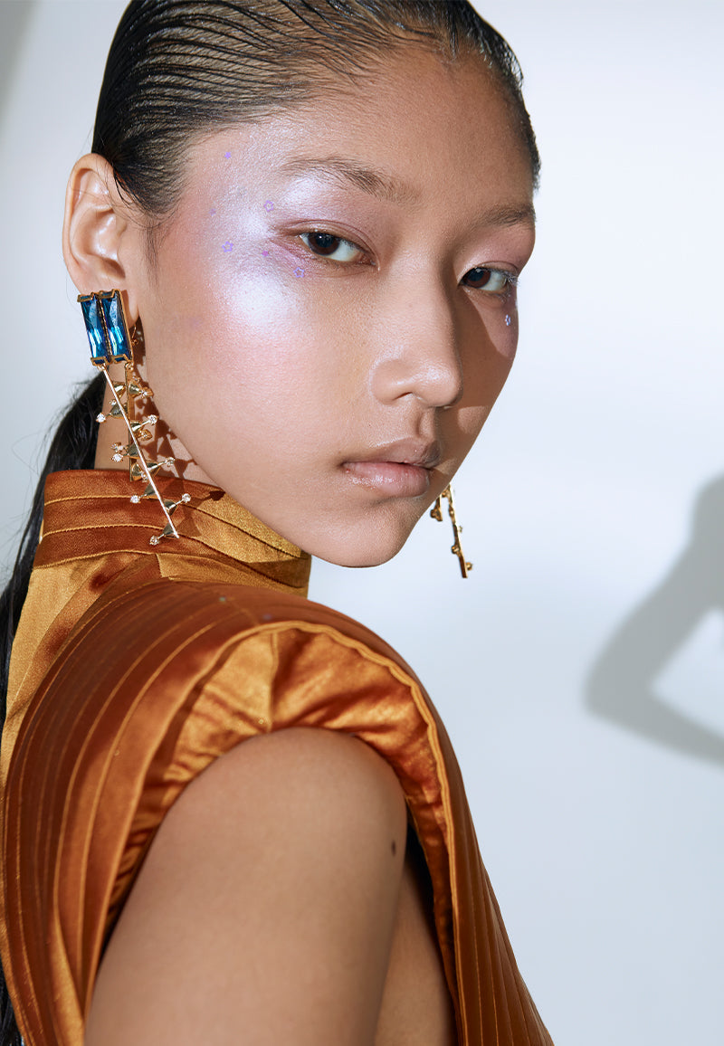 Designed to create a statement, this bodycon bandage dress in rustic gold is cut and constructed using lush satin. The sleeveless midi dress features criss-cross bandage draping with exaggerated shoulder padding and a pleated turtle neck. It has a zip closure at the center back and a flap opening at the back hem for easy movement. It is the perfect dress for your next formal dinner, date night, red carpet or a soiree. Pair yours with heeled sandals or pumps and long gold earrings to complete the look.