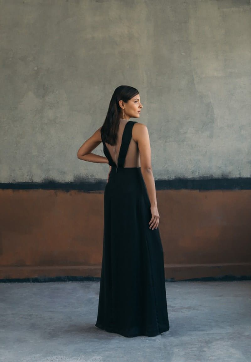 Woman's maxi dress crafted from black satin crepe fabric is a must-have for the evenings. This sleeveless floor-length gown features delicately draped ruching and pleating details with a sheer back made out of net. Style it with minimal gold jewelry and heeled sandals for an elevated look.